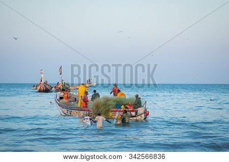 Tanji, The Gambia - November 21, 2019: Scene With Men And Women Carrying Fish From The Boats To The