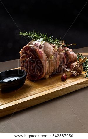 Raw Rolled And Tied Herdwick Sheep Lamb Joint Prepared With Garlic, Rosemary And Sea Salt.