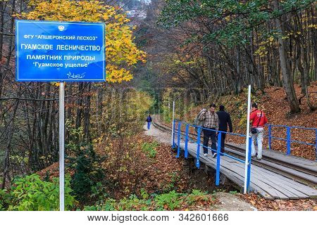 Guamka, Russia - November 4, 2008: Tourists Entering Guam Canyon Walking Along Narrow-gauge Railway 