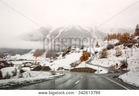 Winding Mountain Road Near The Village Zernez. View Of The Snowy Swiss Alps. Canton Of Graubuenden, 