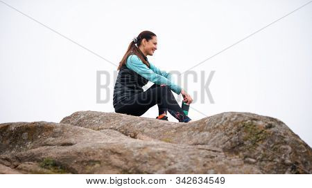 Beautiful Smiling Woman Resting and Drinking Water after Trail Running Outdoor. Workout Exercise at Cold Autumn Evening. Sport and Healthy Active Lifesyle Concept.
