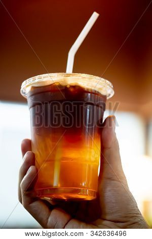 Glass Of Espresso Shot Mixed With Soda Or Sparkling Water In Hand