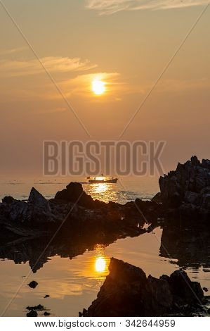 A Fishing Boat That Passes Through The Reef Watching The Sunrise At Dawn