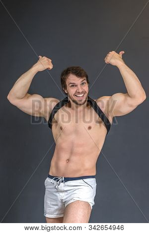 Muscular Strong Athletic Bodybuilder Or Fitness Model Showing Happy Thumbs By Two Hands Up Gesture, 