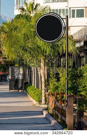 Round Black Signboard On The Street In The City