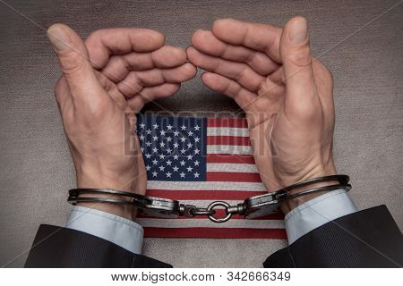 The Hands Of A Businessman In Handcuffs Holding An American Flag 3
