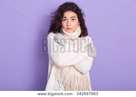 Portrait Of Serious Attractive Female With Curly Black Hair Looking Directly At Camera, Crossing Arm