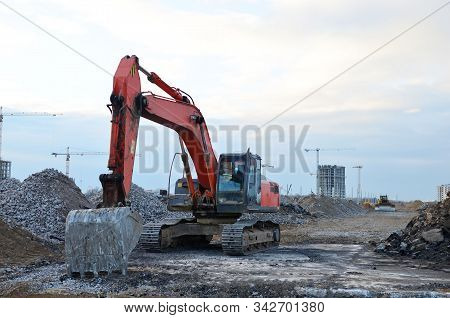Excavator Digs The Ground For The Foundation And Construction Of A New Building. Road Repair, Asphal