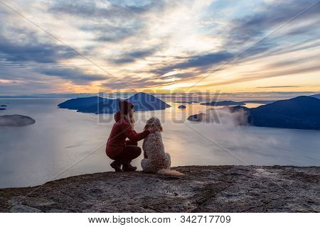 Adventurous Girl Hiking On Top Of A Mountain With A Dog During A Colorful Sunset. Taken On Tunnel Bl