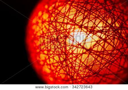 Red knitted fabric lightbulb with strong defocus macrophotography