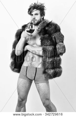 Fashion And Pathos. Richness And Luxury Concept. Guy Attractive Rich Posing Fur Coat On Naked Body. 
