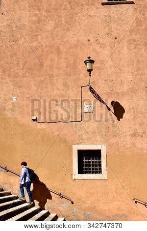 Rome, Italy. October 9, 2019. Ochre Wall, Streetlight And Stairs With Man Climbing At Capitoline Mus
