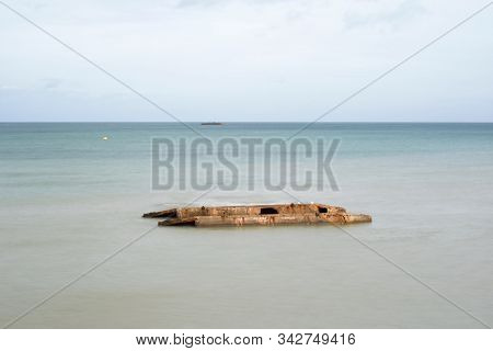 Ruins of harbor built by the Allies in Arromanches, Normandy, France.