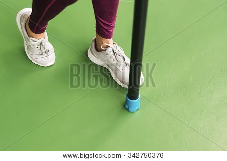 Legs Of Young Fit Woman Doing Exercise With Bodybar In Gym