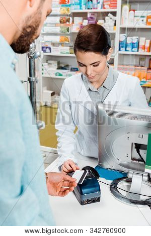 Selective Focus Of Customer With Credit Card Using Paypass In Pharmacy