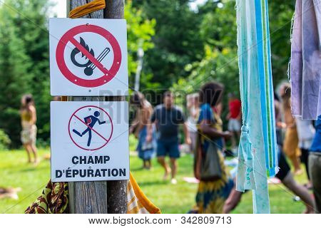 Group Of People Are Seen Blurred Behind A Selective Focus On Ripped Pieces Of Textile And Two Signs 