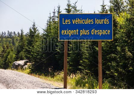 Blue Information Road Sign With French Yellow Writing, Heavy Vehicles Require More Space. On Rural C