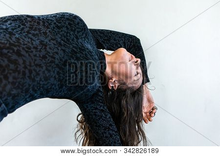 A Closeup View On The Slender Body Of A Woman As She Practices Advanced Vinyasa Yoga, Transitioning 