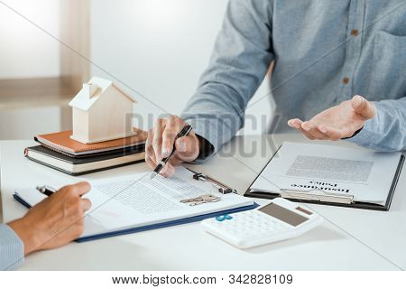 Broker Agent And Customer Holding Pen, The Policyholder And Explain Discussing For Concerning Mortga