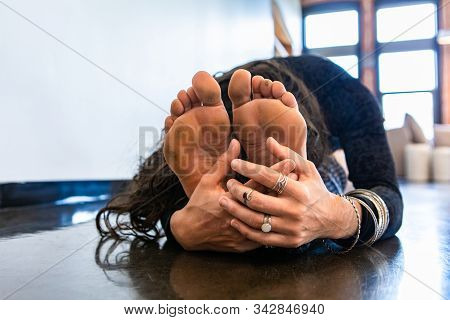 A Closeup View On Dirty And Calloused Feet Of A Fitness Fan During An Advanced Vinyasa Yoga Session,