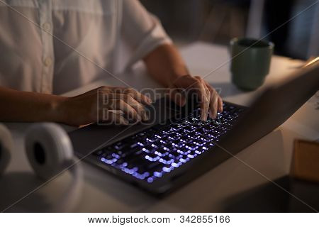 Close-up Of Businesswoman Typing On Laptop Computer With With Backlit Computer Keyboard Till Late Ev