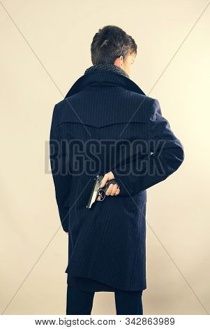 A Man Holding A Gun On His Back. The Gunman Held His Gun Behind Him.crime Concept.criminality Concep
