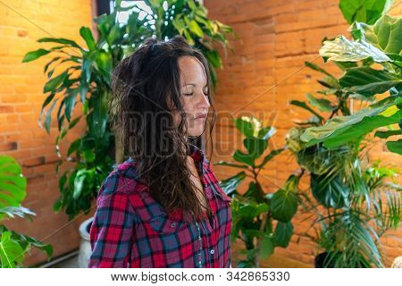 A Close Up, Head And Bust Shot Of A Woman Wearing A Red Checkered Shirt Standing And Meditating Indo