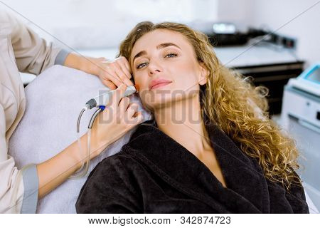 Face Skin Care. Close-up Of Pretty Blond Curly Woman Getting Facial Hydro Microdermabrasion Peeling 