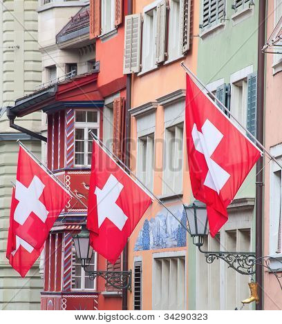 Gamle gade Augustinergasse i Zürich dekoreret med schweiziske flag