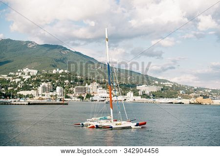 Yalta. Crimea. Russia - August 31, 2017: Port of Yalta in Crimea. Moored Trimaran on Foreground.