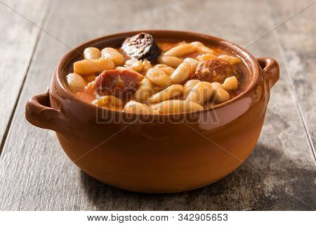 Typical Spanish Fabada Asturiana On Wooden Table