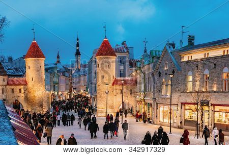 Tallinn, Estonia - December 3, 2016: People Walking Near Famous Landmark Viru Gate In Street Lightin