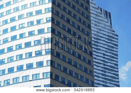Geometric Reflection: Partly Cloudy Sky Reflected By Window Panes Of Office Building. Surface Of Gla