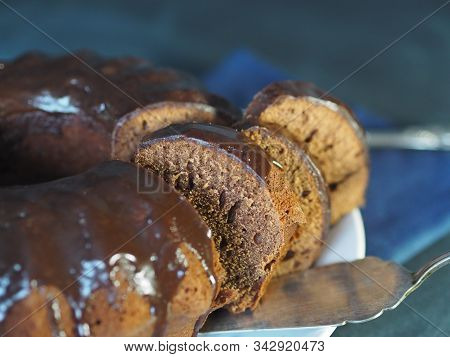 Chocolate Round Cupcake, Glazed, On A Wooden Background With Fir Branches. We Meet Christmas.