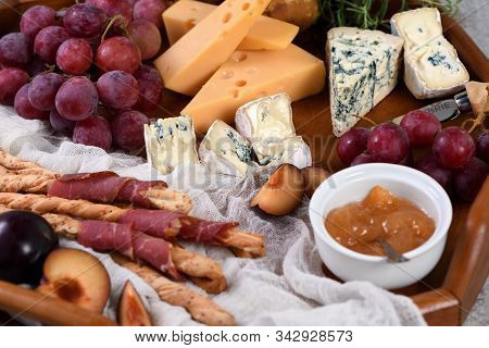 Antipasto. Dish With Crispy Grissini Wrapped In Sun-dried Bacon, Slices Of Brie Cheese, Camembert, B