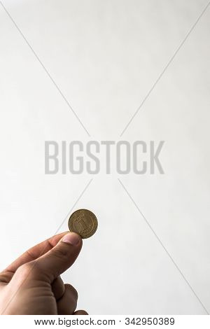 Coin In Male Hand On Wall Background