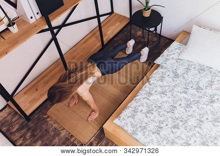 Attrctive Fitness Woman Doing Stretching Exercises At Home, As Part Of A Healthy Lifestyle Without G