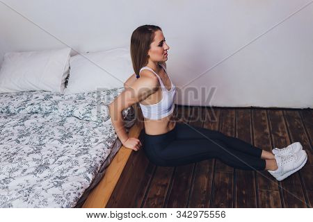 Attrctive Fitness Woman Doing Stretching Exercises At Home, As Part Of A Healthy Lifestyle Without G