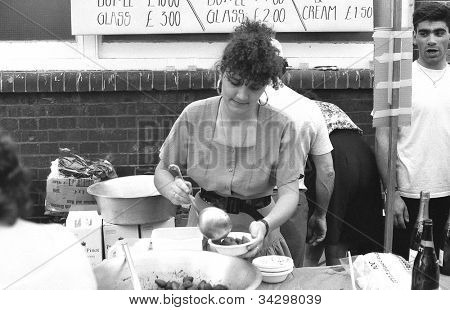 LONDON - 21 juli: En kvinde støbeskeer jordbær på italiensk street-party i Warner Street, Clerkenw