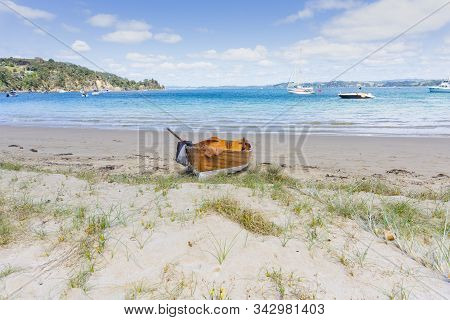 Old-fashioned Wooden Clinker Dinghy Pulled On Beach In Vivian Bay, Kawau Island New Zealand.