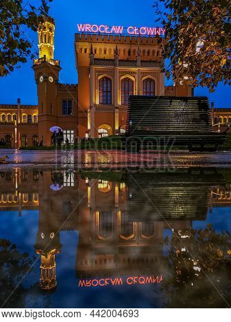 Wroclaw, Poland - October 30 2020: Facade Of Main Railway Station With Small Wooden Bench In Front O