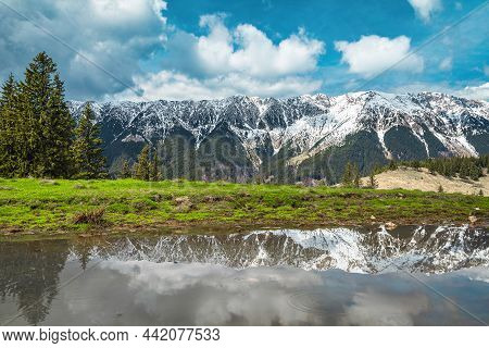 Stunning Nature Scenery With Lake And High Snowy Piatra Craiului Mountains In Background, Near Peste