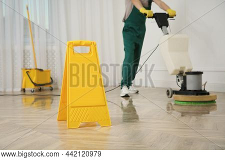 Professional Janitor Cleaning Parquet Floor With Polishing Machine Indoors, Closeup