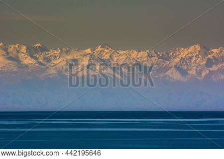 Sunset On The Background Of The Mountain Lake Issyk-kul Kyrgyzstan, Mountain Lake And Snowy Summer P