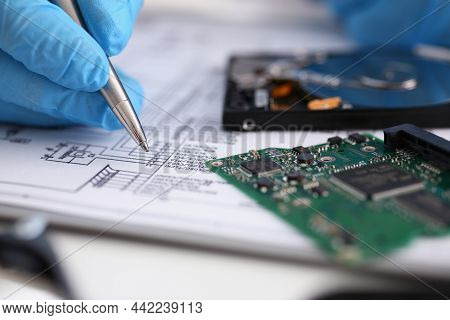 Close-up Of Male Fill Information In Papers With Silver Pen Wearing Gloves. Computer Details On Desk