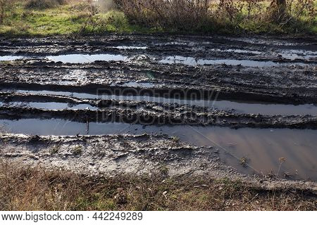 Bad Muddy Dirt сountry Road After The Rain Puddles And Car Track.