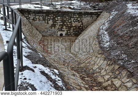 Sewer Gutter Paved With Granite Stone And Dikes Drains Rainwater By Ditch At The Highway Into The Re