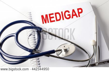 Notebook With Text Medigap With Pen And Stethoscope, Medicina