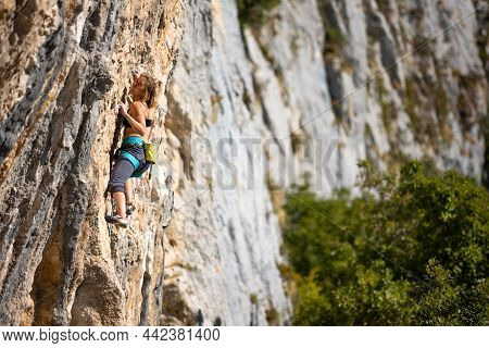 A Strong Girl Climbs A Rock At A High Altitude, A Climber Trains On The Rocks, Training Strength And