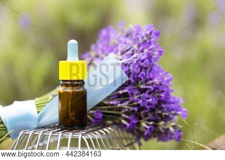 Brown Glass Bottle With Dropper Of Lavender Essential Oil With Fresh Lavender Flowers On Natural Lav